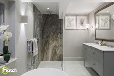 a bathroom with a tub, sink and large mirror on the wall next to it