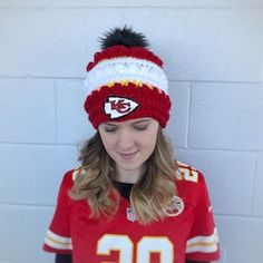 a young woman wearing a knitted hat with a football jersey and number on it