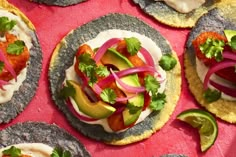 several tortillas with various toppings on top of each other and sliced avocado