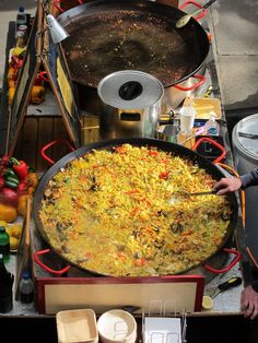 a large pan filled with food sitting on top of a table next to other foods