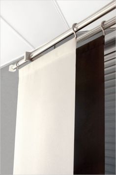 a white and black curtain hanging from a metal rod