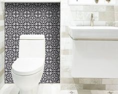 a white toilet sitting next to a bathroom sink under a faucet in a bathroom