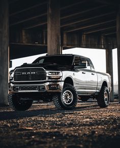 a white ram truck parked under an overpass