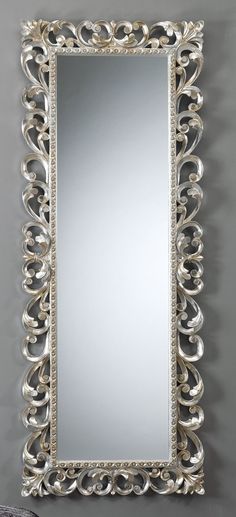 an ornate silver mirror hanging on the wall