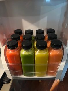 a refrigerator filled with lots of different colored drinks in it's door drawer,