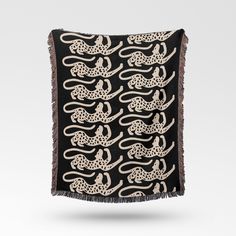 an embroidered black and white scarf with leopards on the front, fringed in gold thread