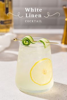 white linen cocktail with lemon and cucumber garnish on the rims