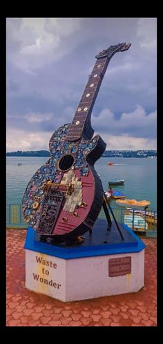 a large guitar sculpture sitting on top of a blue block