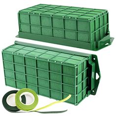 two green plastic containers with tape on the side and another container behind them, both stacked up against each other