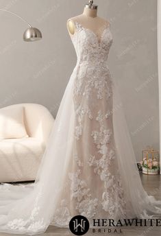 a wedding dress on display in front of a white couch