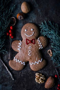 a ginger with a bow tie and some nuts on the side, surrounded by other christmas decorations