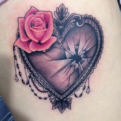 a heart tattoo with a rose and diamond on the back of its stomach is shown