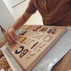 a child is playing with rocks and letters on a wooden board that has the word love spelled in it