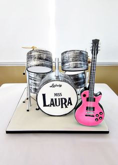 a cake that is shaped like a guitar and drums on top of a white table