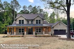 a large house with a metal roof in the middle of a field next to trees