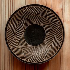 a black plate sitting on top of a wooden table