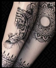 a woman's leg with tattoos on it and a tiger in the middle of her legs