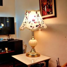 a lamp on a table in front of a television