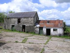 an old stone building sitting on top of a dirt field