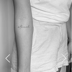 a woman with a small tattoo on her arm that reads, friend in cursive font