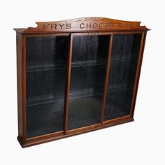 a wooden display case with glass doors and writing on the front, which reads fry's chocolates