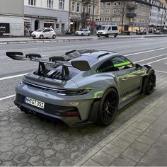 a grey sports car parked on the side of a street