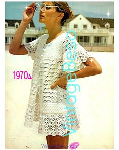 a woman in white dress standing on the beach with her hand under her eyeglasses