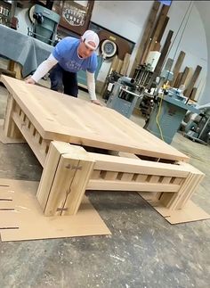 a man working on a wooden table in a shop