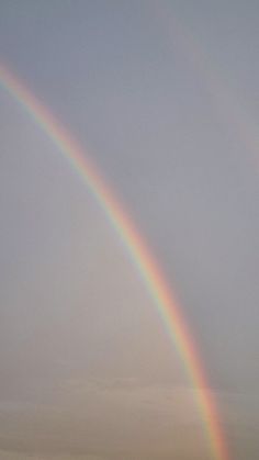 two rainbows are in the sky over a beach