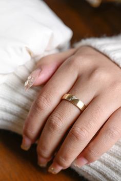 a woman's hand with a gold ring on it