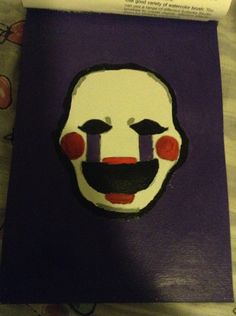 a close up of a cake with a clown's face painted on the side