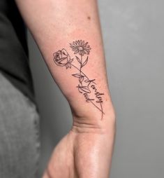 a woman's arm with a flower tattoo on the left side of her hand