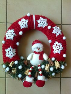 a knitted wreath with a snowman on it