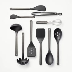 an assortment of kitchen utensils arranged on a white surface with spoons and spatulas