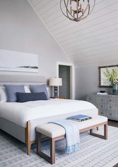 a bedroom with a large bed and blue accents on the walls, along with a white rug