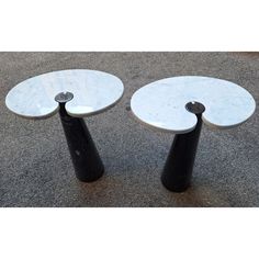 two white and black tables sitting on the ground