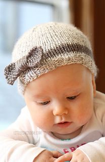 a baby is wearing a knitted hat and looking down