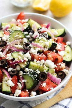 greek cucumber salad with feta cheese and olives in a white bowl