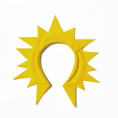 a yellow headband with spikes on it's sides and an oval shaped hole in the middle