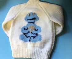 Super cute hand knit Cookie Monster sweater White and blue Giggly eggs on both front and back. Light weight(not wool) 2 1/2" ribbed waist and sleeves Waist is 16"around Arm length from collar to edge of ribbing 14" Top collar to bottom is 14" Probably fit 2-4 year old In excellent preloved condition Cute Hand Knitted Blue Sweater, Cute Blue Hand-knitted Sweater, Cute Blue Hand Knitted Sweater, Cozy Handmade White Sweater, Cute White Handmade Sweater, Cute Handmade White Sweater, Cute Hand Knitted White Sweater, Cute White Hand Knitted Sweater, Handmade White Knit Sweater