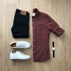 a pair of white shoes, brown shirt and black pants are laid out on the floor