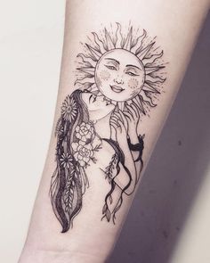 a woman's arm with a sun and feathers tattoo design on the left forearm