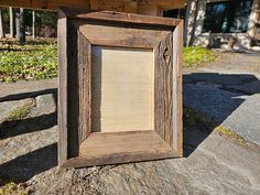 a wooden frame sitting on top of a rock