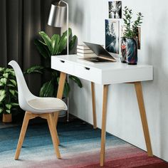 a white desk with a laptop on top of it next to a potted plant