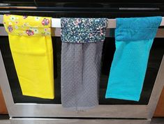 three pairs of colorful socks hanging on a clothes line in front of an oven door