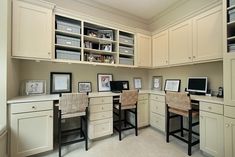 a home office with two desks and several pictures on the wall above them,