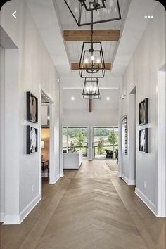 a large open floor plan with wood floors and chandelier hanging from the ceiling