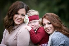 two women and a child are smiling for the camera while they both have their arms around each other