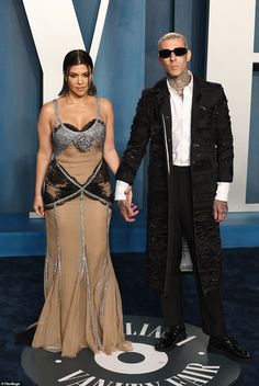 an image of a man and woman in formal wear posing for the camera on the red carpet