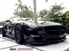 a black sports car parked in front of some palm trees